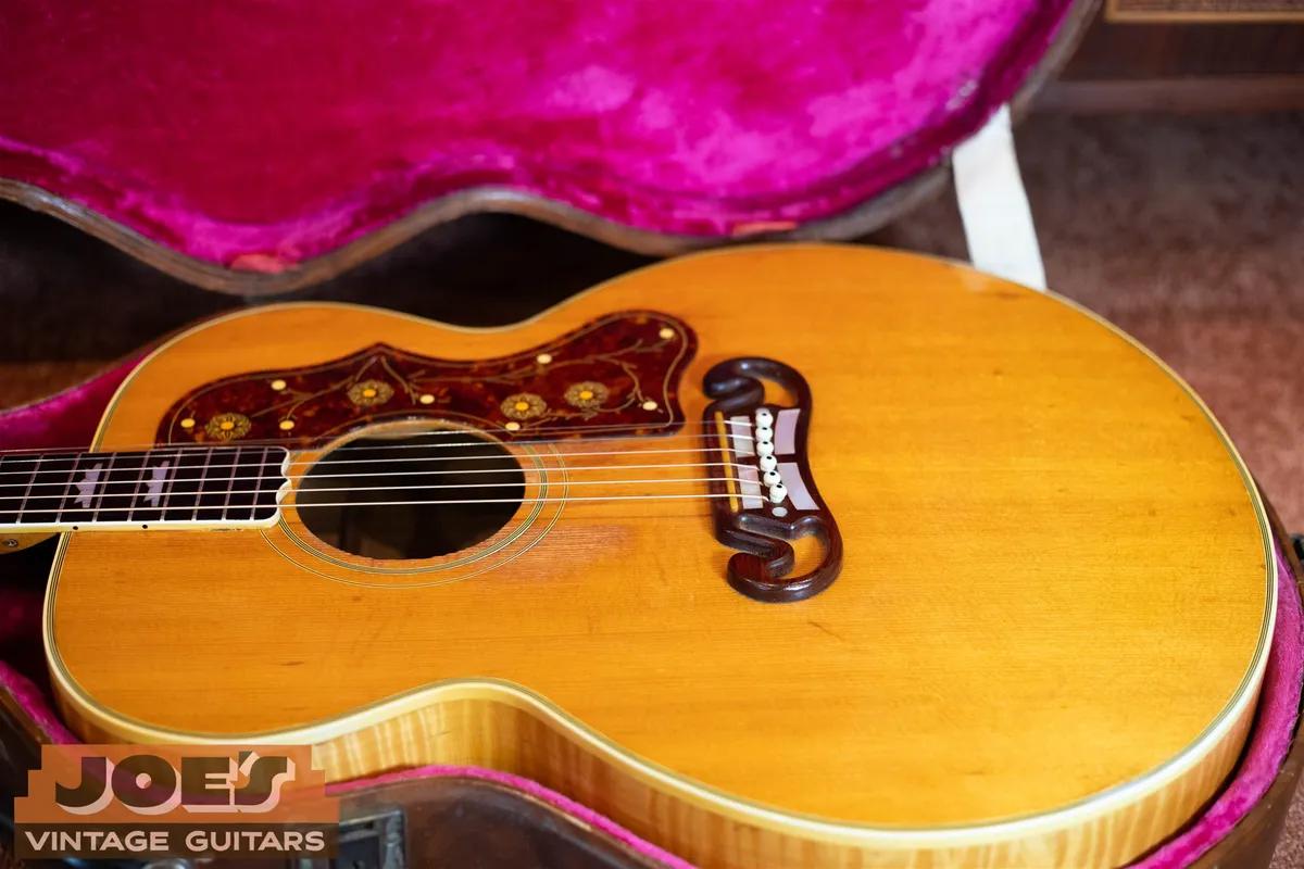 Close view of a 1950s Gibson J-200 open moustache bridge and natural spruce top
