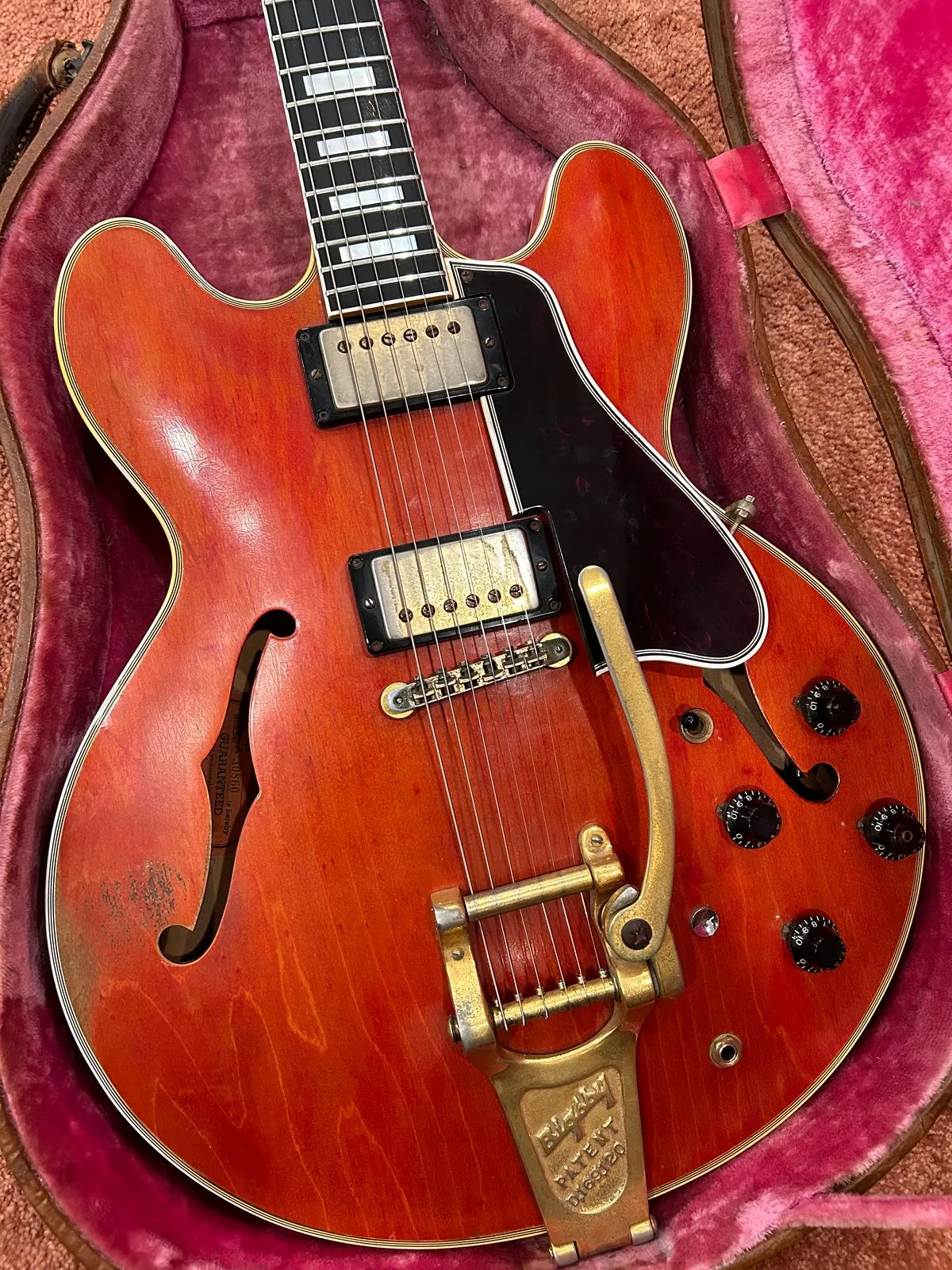 Front of the cherry 1959 Gibson ES-355 in its pink-lined case with gold Bigsby