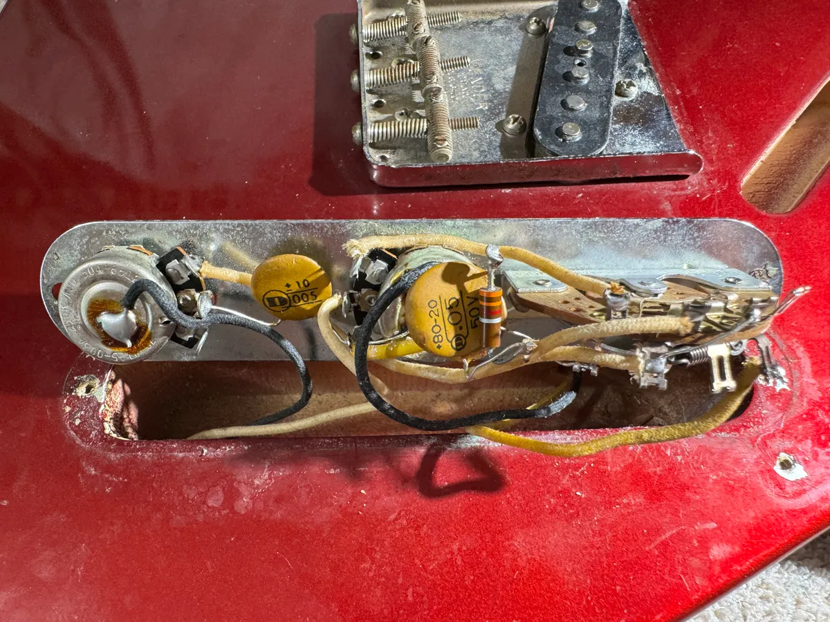 1965 Fender Esquire control cavity with three-way switch, cloth wire, capacitors, resistor, and dated potentiometers