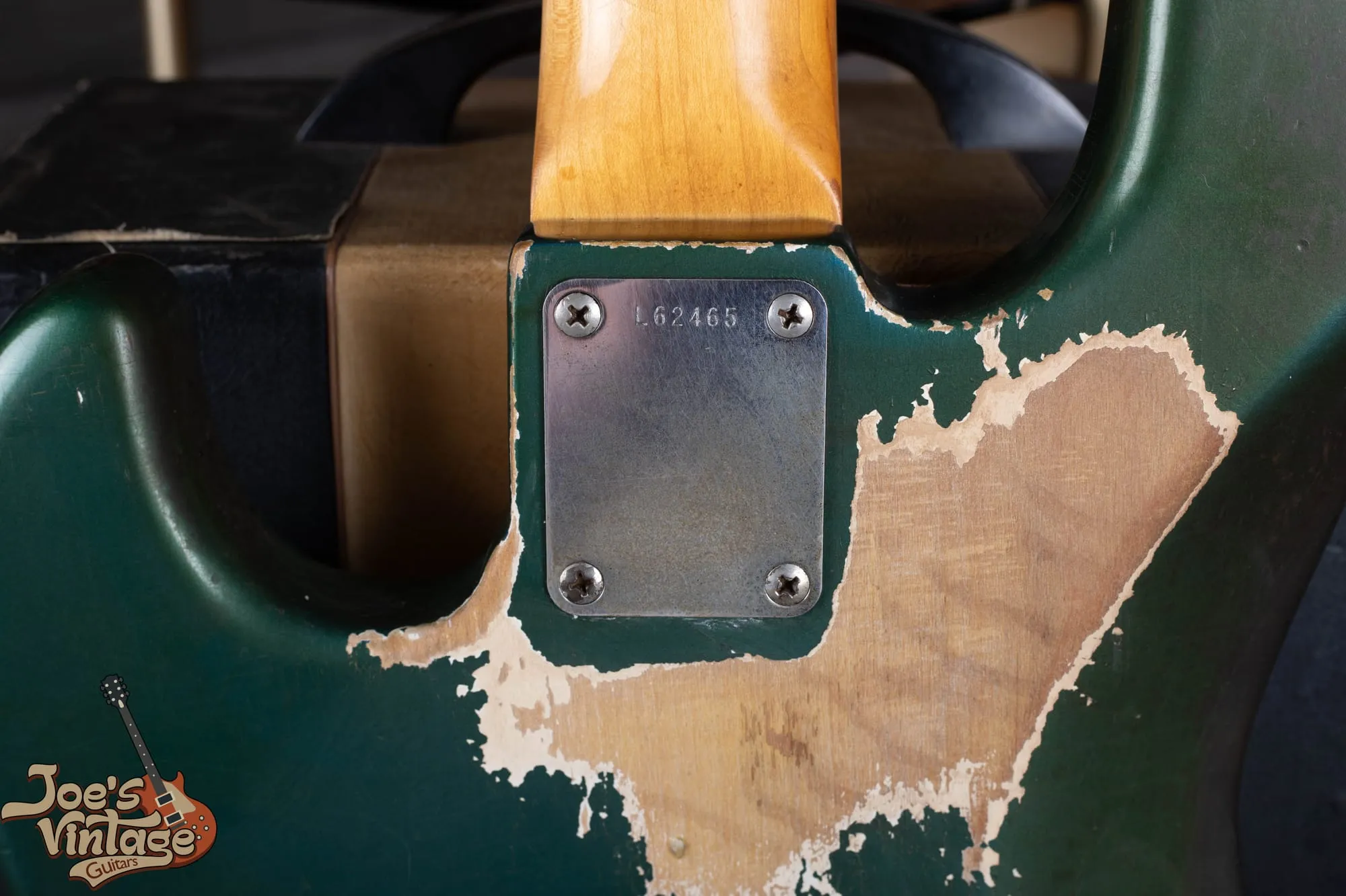 Back of a 1966 Fender Jazz Bass in Lake Placid Blue that has aged heavily toward green, with very large areas of finish worn through to bare wood, white undercoat visible at the borders of the wear, and the serial number neck plate reading L62465.