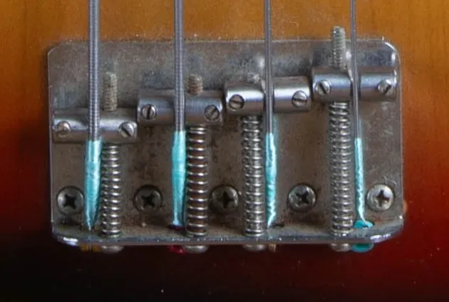 Close-up of the 1973 Fender Jazz Bass vintage 4-saddle bridge with steel saddles