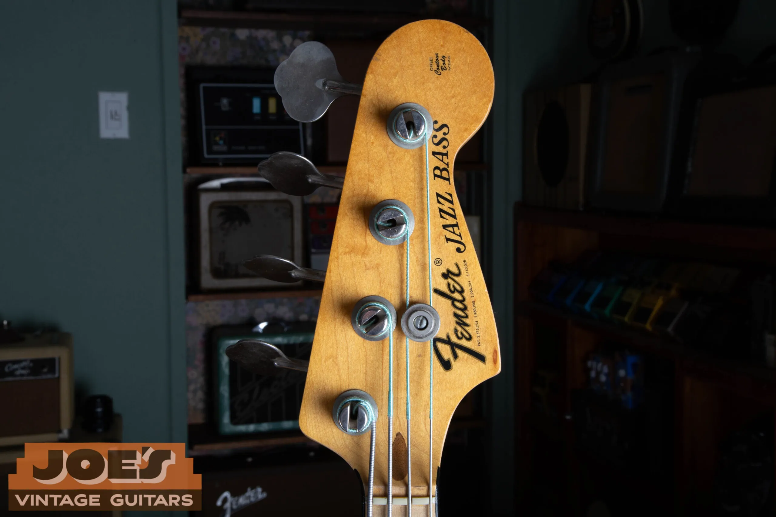 Front of the 1973 Fender Jazz Bass headstock showing the bold black CBS-era Fender decal and Fender-stamped tuning machines