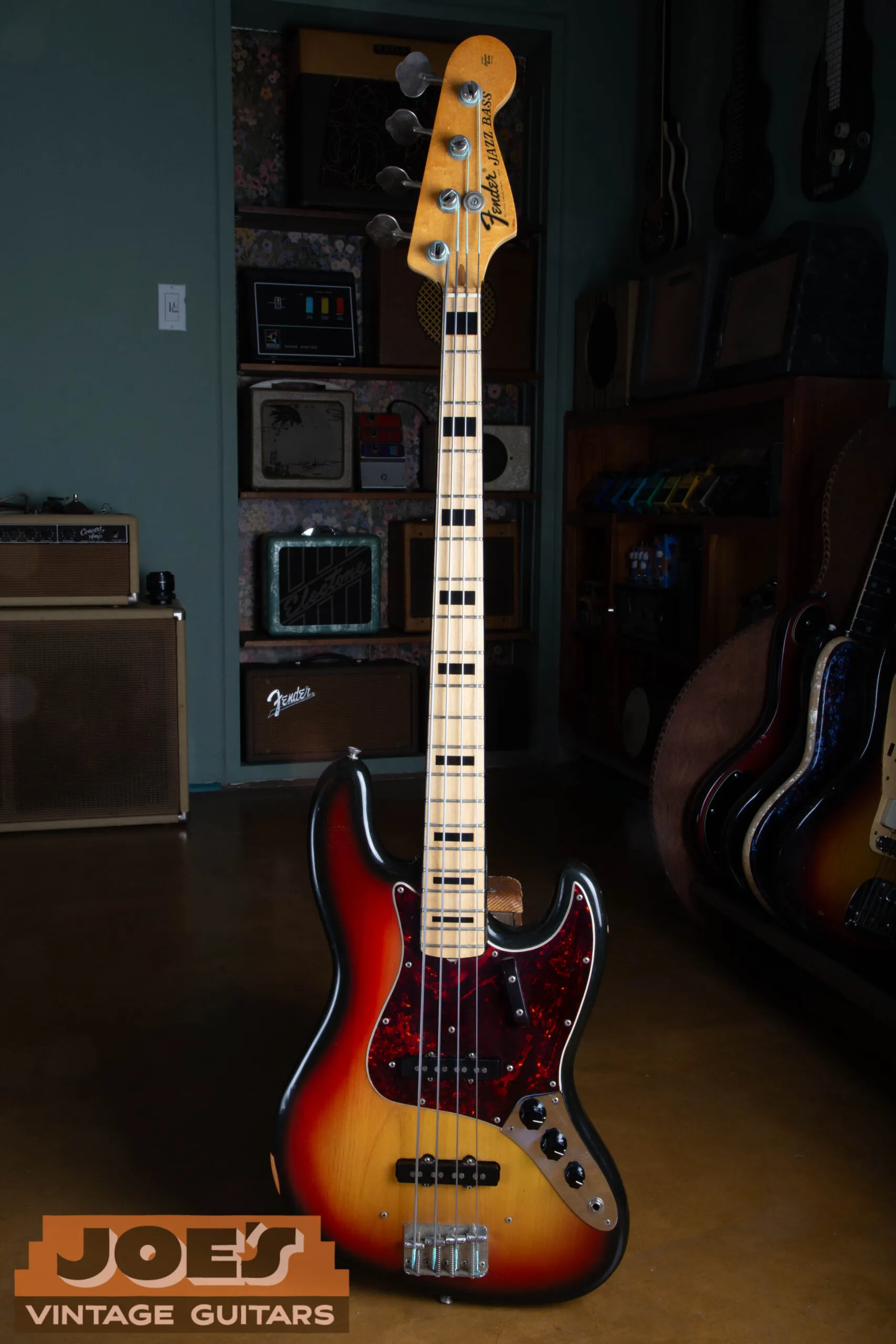 1973 Fender Jazz Bass in 3-color sunburst, full front view showing the maple fingerboard with black block inlays, two single-coil pickups, and chrome control plate