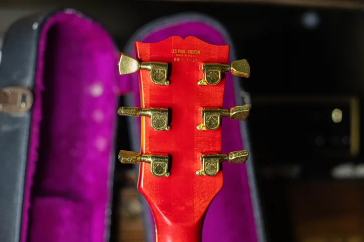Gold Les Paul Custom marking and 00-prefix serial 00115029 on a red Gibson headstock