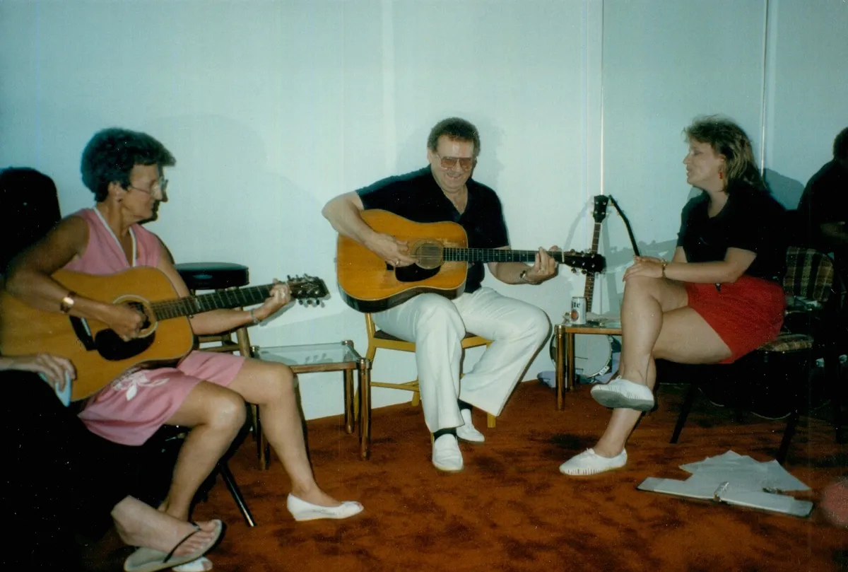 Bill Minnich seated and playing the 1955 Martin D-28 during a family gathering