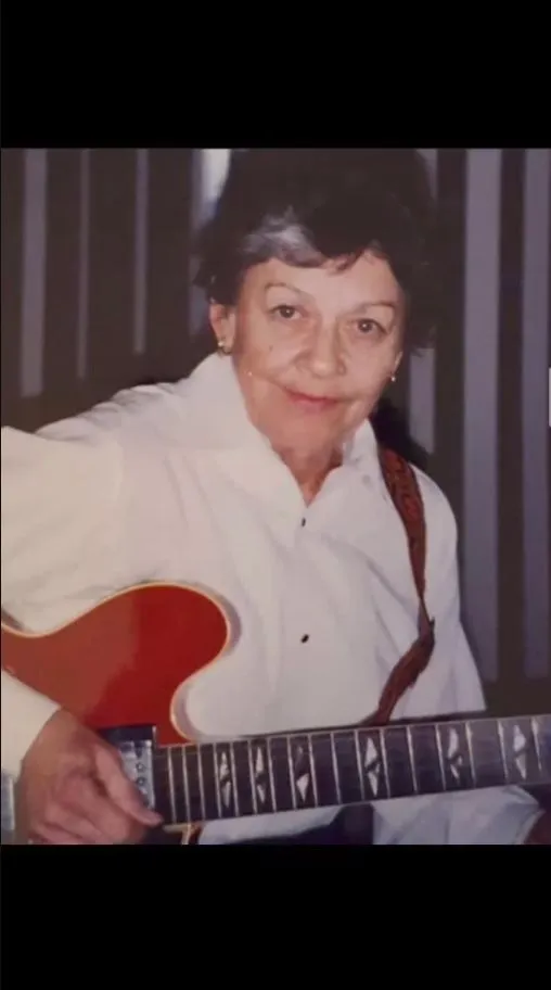 Edward's wife playing a vintage guitar in the original family photograph