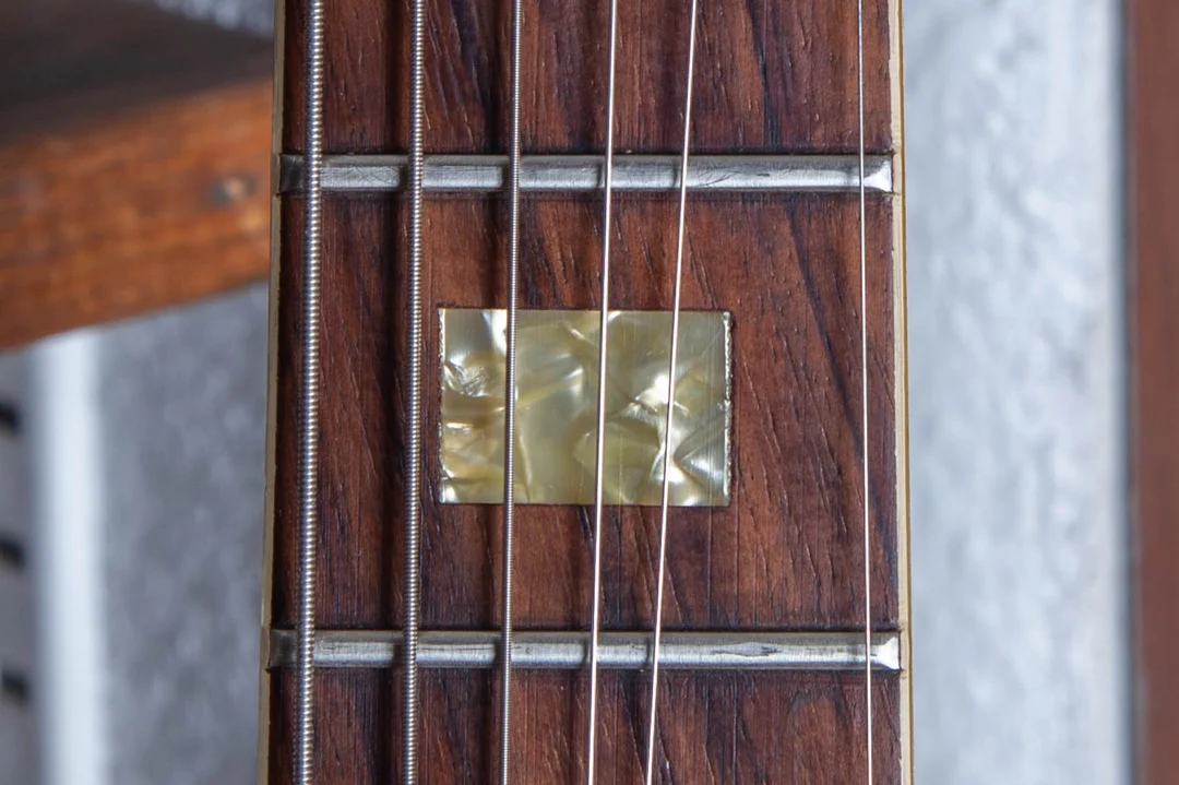 Small rectangular pearl block in a rosewood ES-335 fingerboard