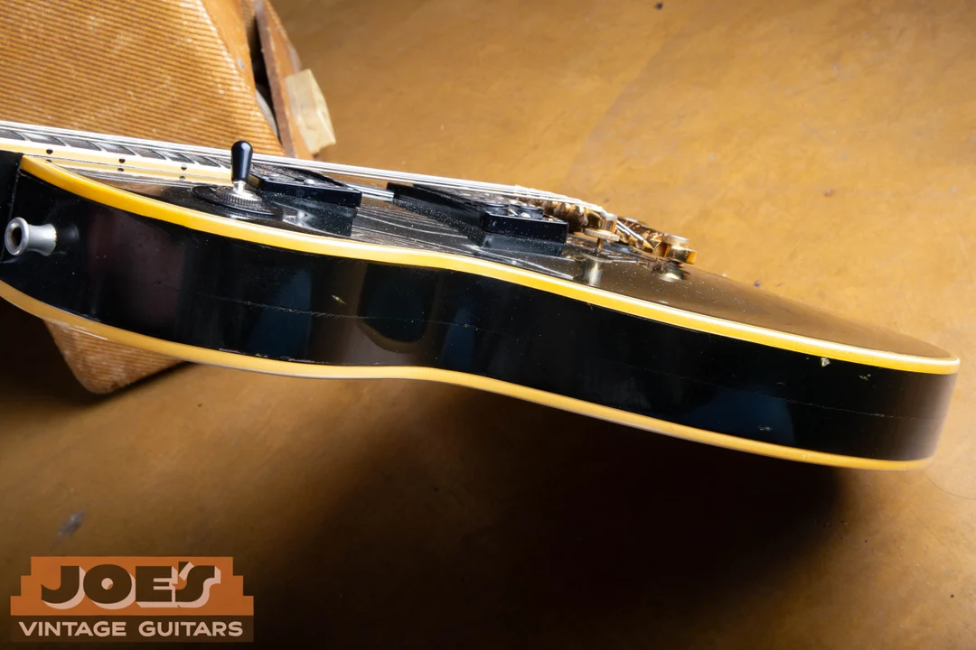 Black Gibson Les Paul-family body edge showing a faint horizontal line in the side finish