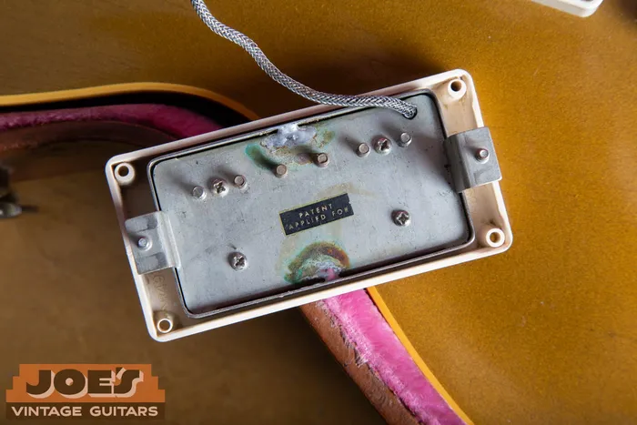 Underside of an original Gibson PAF humbucker showing the Patent Applied For sticker, aged solder joints, and heavy oxidation on the nickel silver baseplate. We buy vintage Gibson guitars and pickups nationwide at Joe's Vintage Guitars.