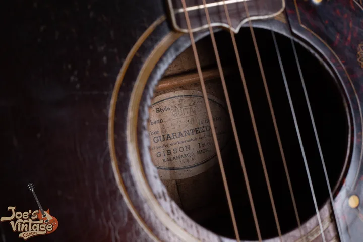 White oval Gibson interior label with a faint A-prefix serial visible through the soundhole