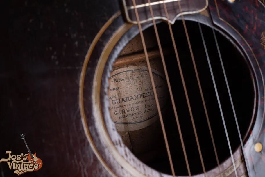 Vintage Gibson white oval interior label showing handwritten serial number from the early Kalamazoo era