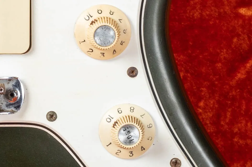 Fender Jazzmaster witch hat knobs close-up, white plastic with chrome domed top, CBS era indicator introduced mid-1965 replacing Strat-style dome knobs