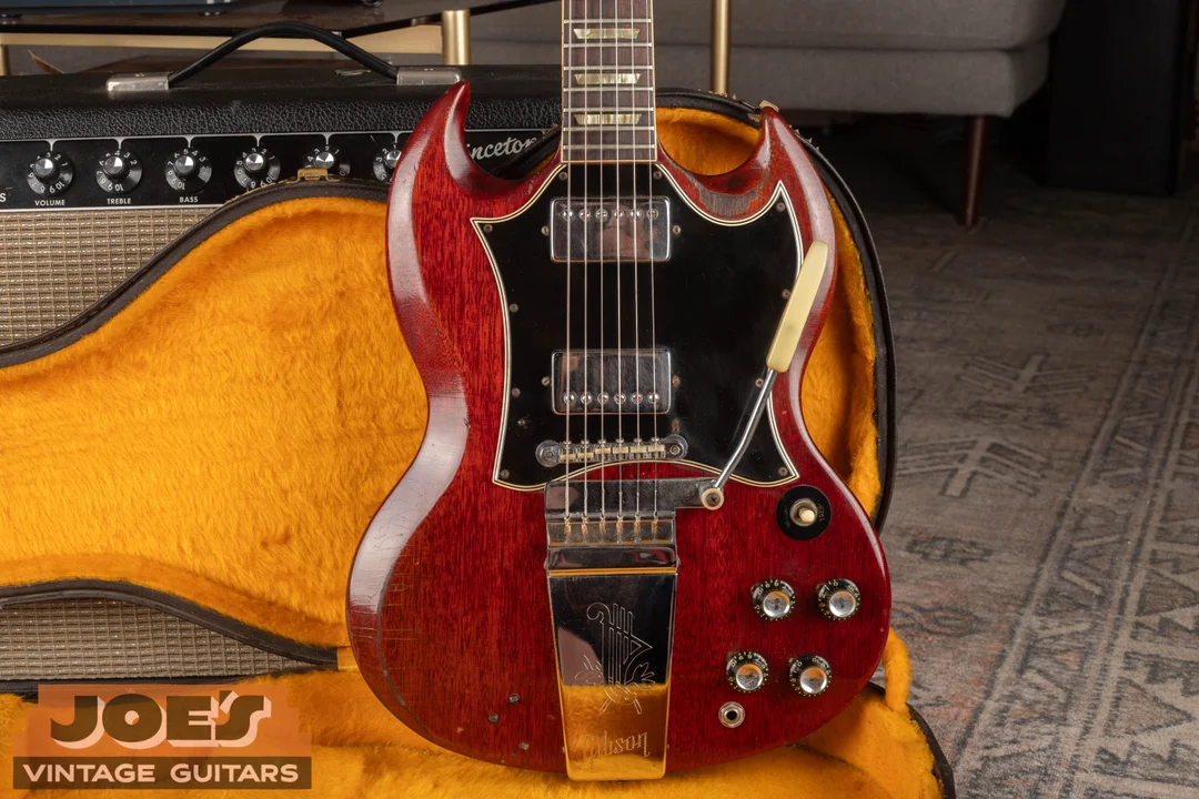 Cherry SG Standard with a large black batwing guard surrounding both humbuckers, without separate pickup rings