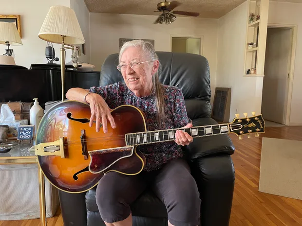 The original owner's daughter holding her father's 1954 Gibson L-5C