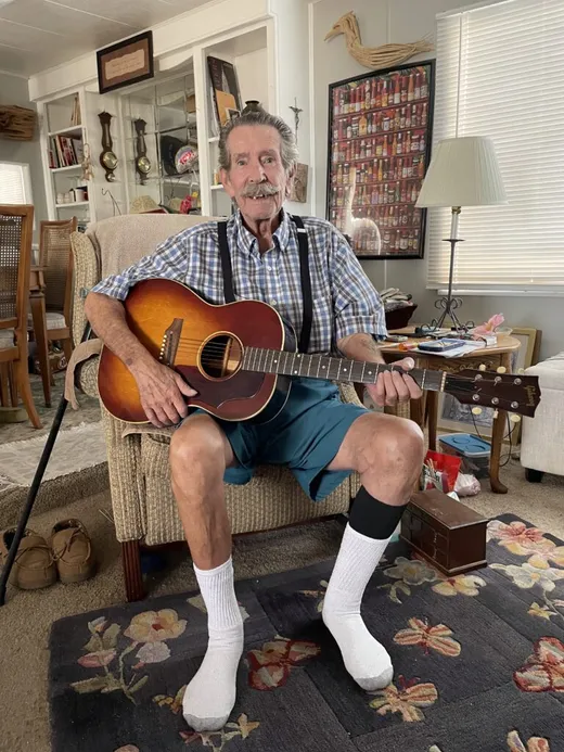 Happy client Lyman playing a 1960s Gibson B-25 acoustic guitar after selling it to Joe